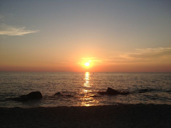 Un tramonto sull'oceano con cielo blu e arancione.
