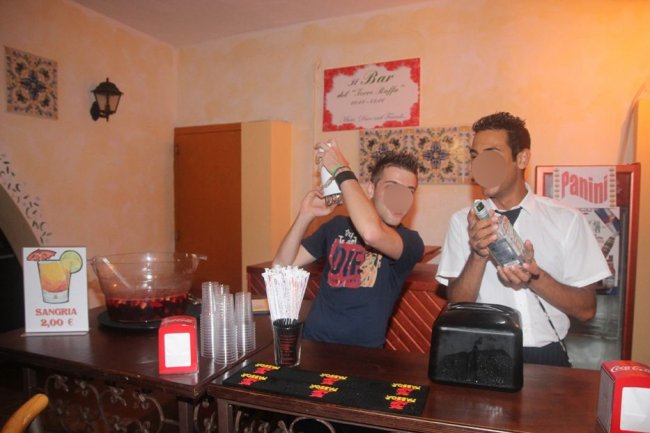 Due persone preparano bevande al bar.