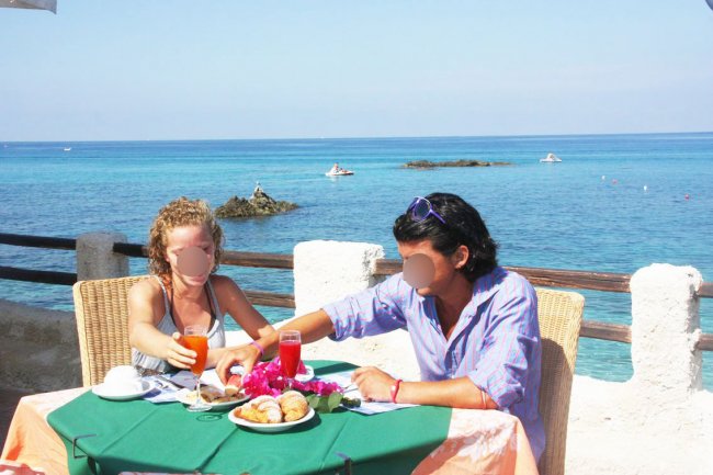Coppia che mangia davanti al mare.