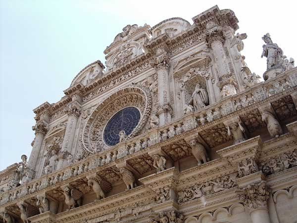 Facciata decorata di una chiesa con intricati rilievi e una grande rosetta.