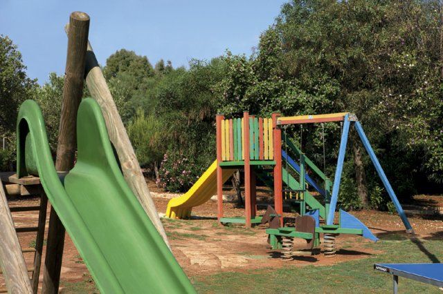 Scivoli colorati e altalene in un parco giochi all'aperto.