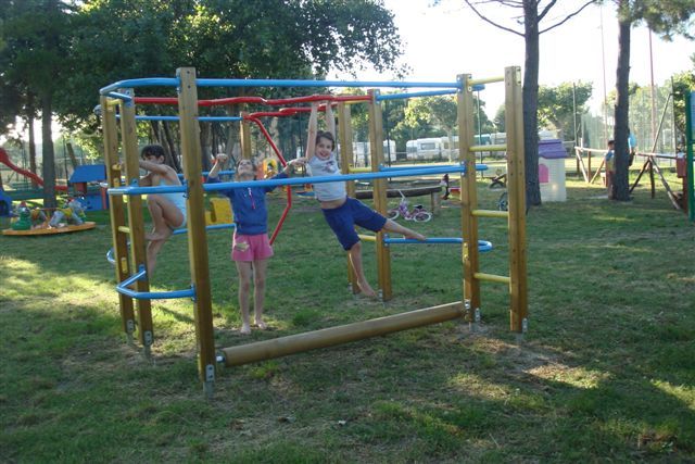 Tre ragazzi si divertono su una struttura di arrampicata in un parco.