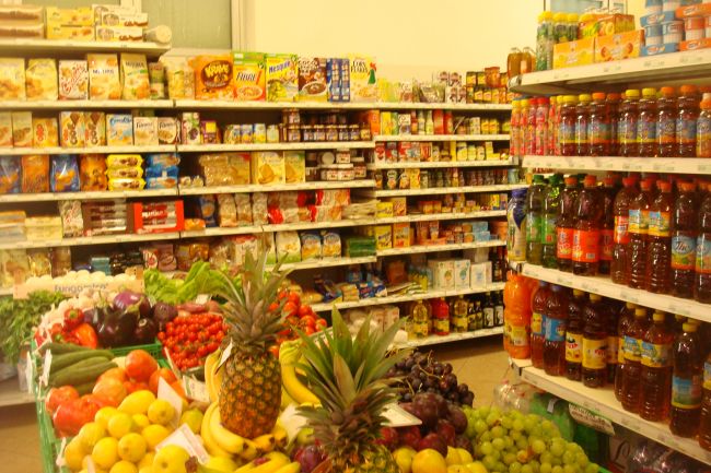 Scaffali di supermercato con frutta e prodotti confezionati.