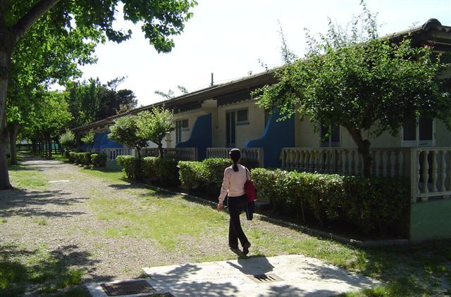 Persona cammina accanto a cottage con terrazze alberate.