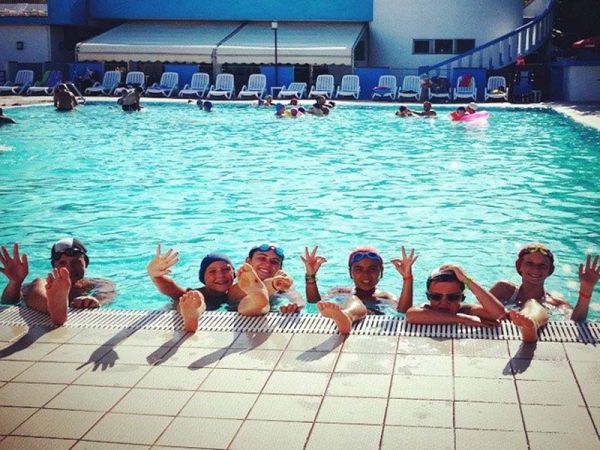 Persone sorridenti in piscina.