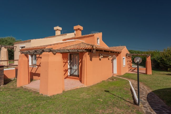 Esterno di una casa arancione con tetto in tegole.