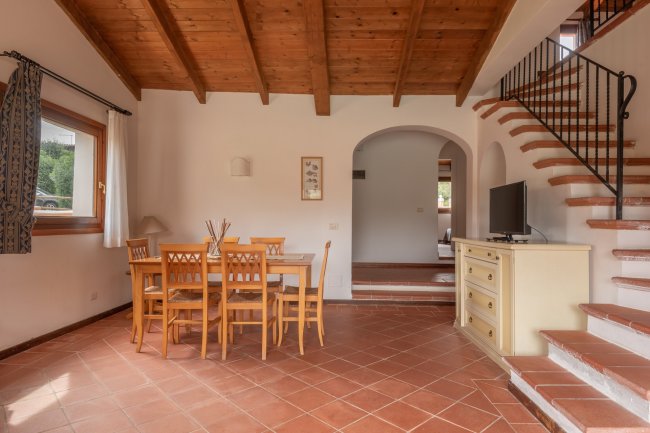 Sala da pranzo con tavolo e sedie in legno.
