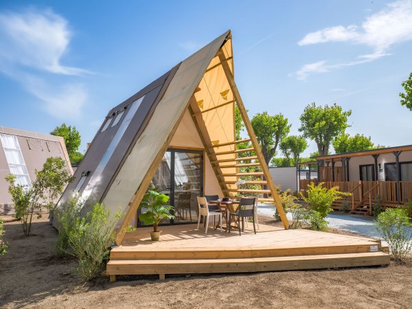 Bungalow a forma di A con veranda e arredi esterni.