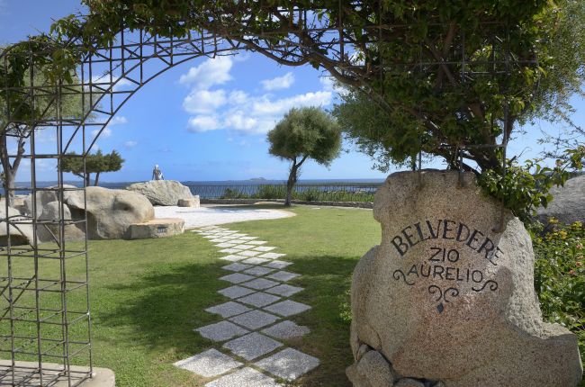 Giardino con arco di piante e sentiero verso il mare.