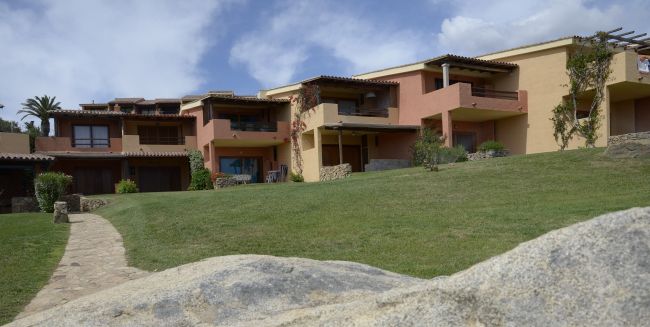 Edifici residenziali in stile mediterraneo su prato verde.