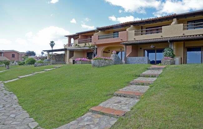 Edificio con ampio prato e sentieri in pietra.