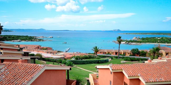 Tetti di case con vista sul mare e cielo azzurro.
