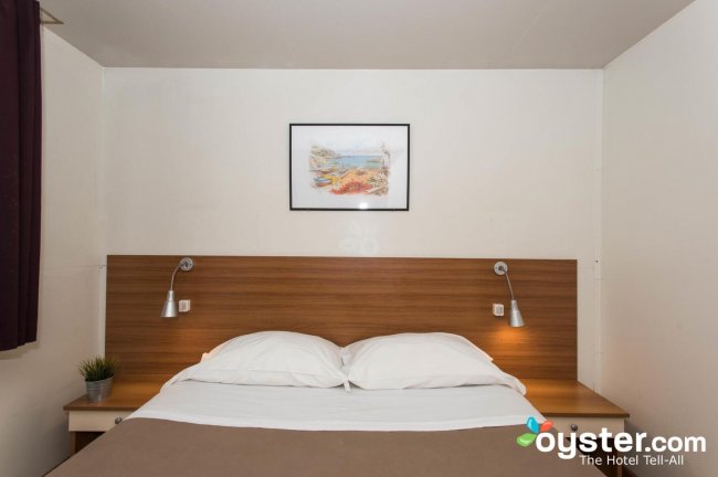 Camera con letto matrimoniale, comodini e quadro appeso.