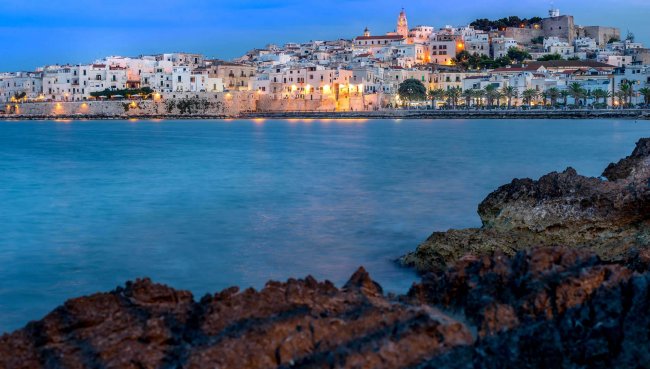 Vista notturna di una città costiera illuminata.
