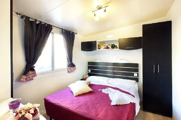 Camera da letto con letto matrimoniale e arredamento moderno.