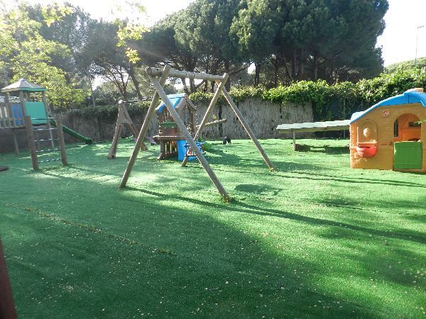 Un parco giochi all'aperto con altalene e casette.