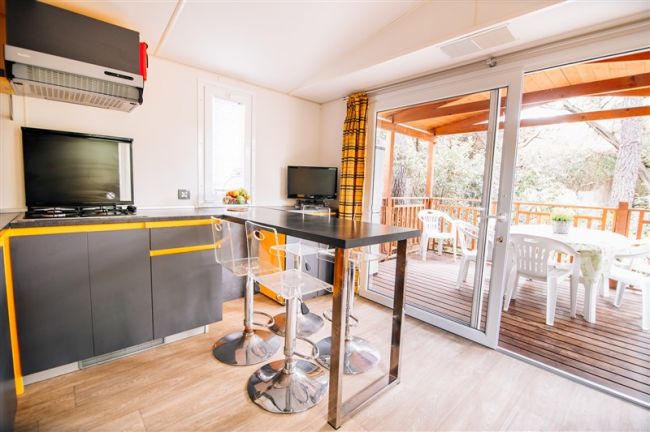 Cucina moderna con tavolo alto e sedie trasparenti.