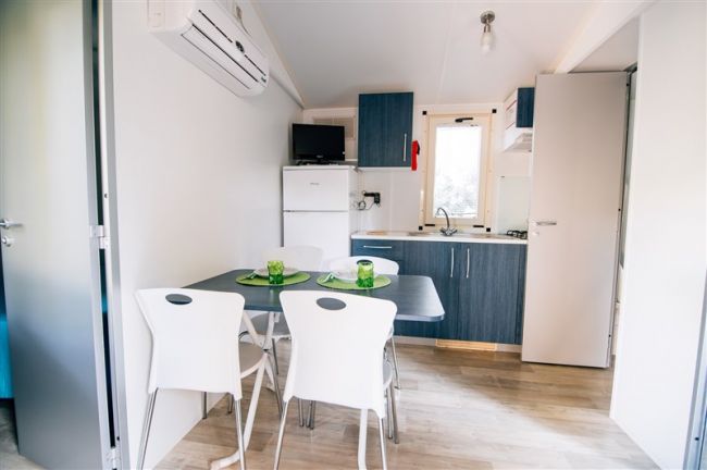 Cucina moderna con tavolo da pranzo e sedie bianche.