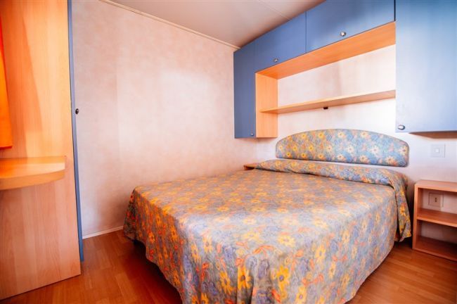 Camera con letto matrimoniale e armadi blu.