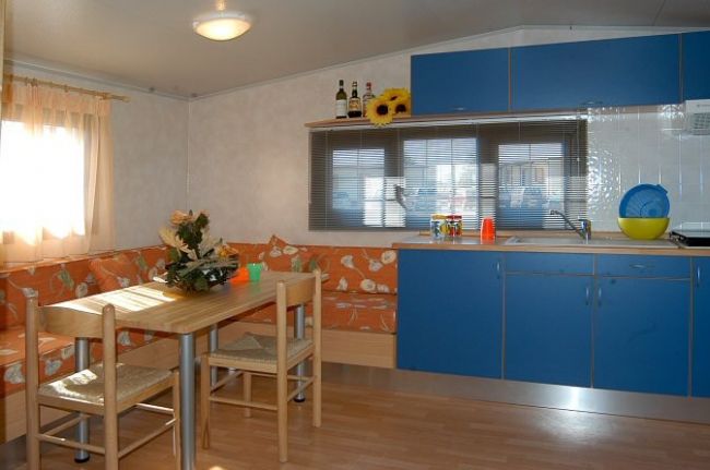 Cucina e zona pranzo con mobili blu.