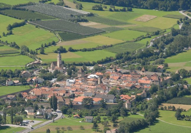 Un villaggio con tetti arancioni in una valle verde.
