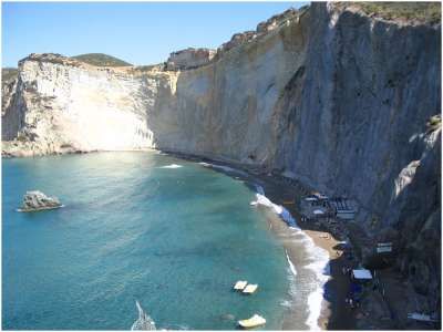 Una spiaggia con scogliera a picco sul mare e acque turchesi.