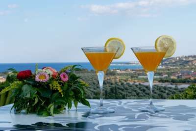 Due cocktail con fette di limone su un tavolo, vista mare.
