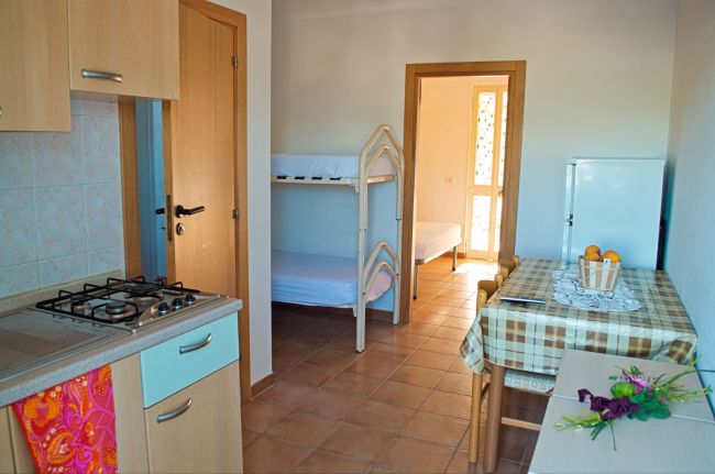 Cucina con letto a castello in fondo.