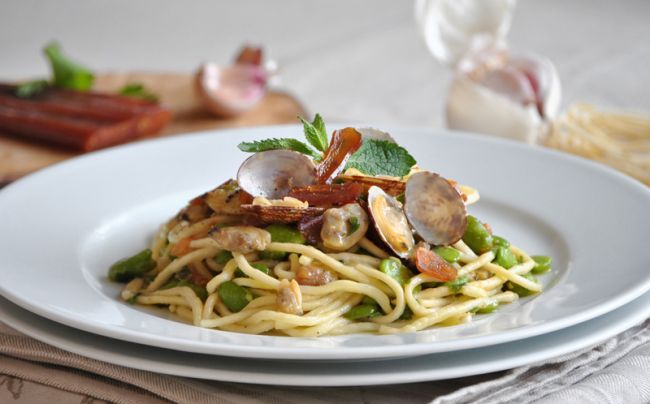 Piatto di spaghetti con vongole e verdure.