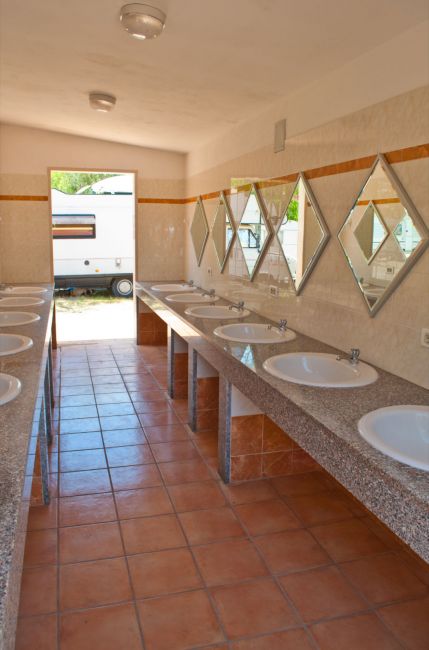 Bagni con lavandini e specchi in fila.