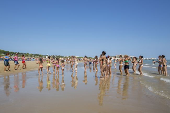 Persone in costume ballano sulla spiaggia.