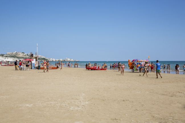 Spiaggia affollata con ombrelloni colorati.