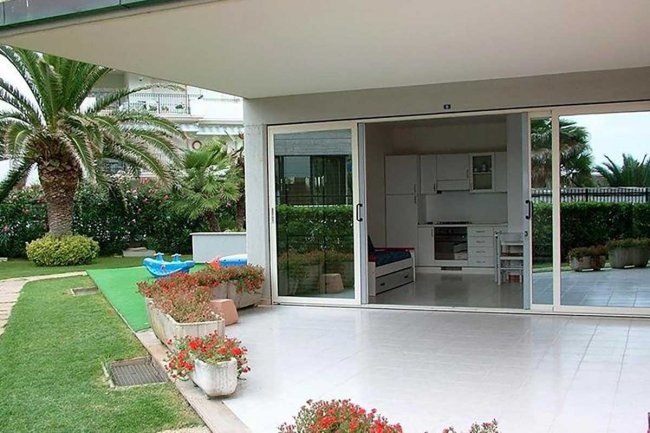 Giardino con patio e vista su interni moderni.