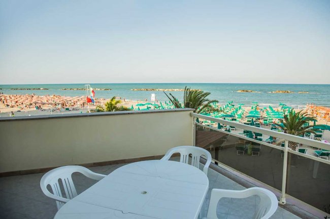 Balcone con tavolo e sedie vista mare.