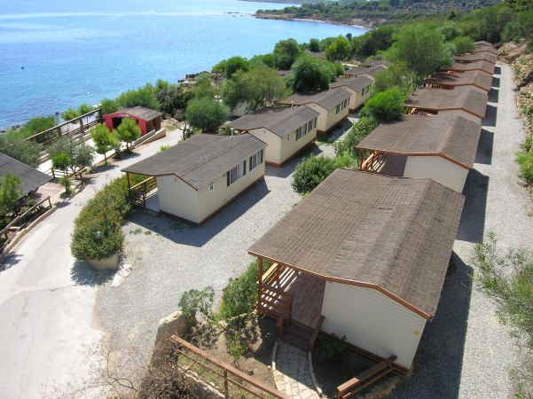 Vista aerea di bungalow sulla costa con vegetazione.