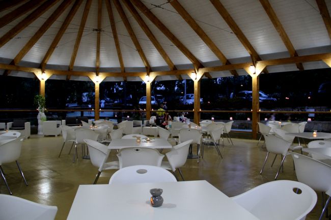 Sala ristorante con tavoli e sedie bianche.