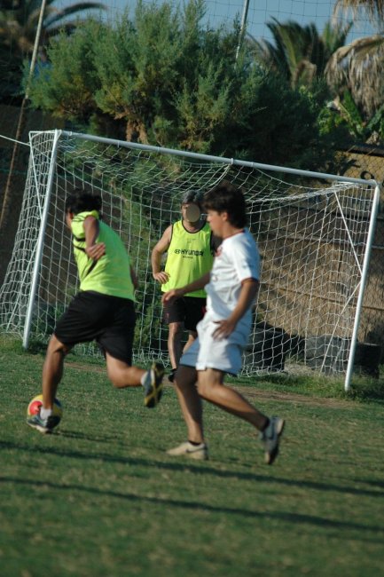Due persone giocano a calcio vicino a una rete.