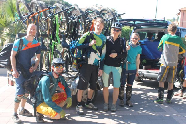 Un gruppo di ciclisti davanti a un'auto piena di biciclette.
