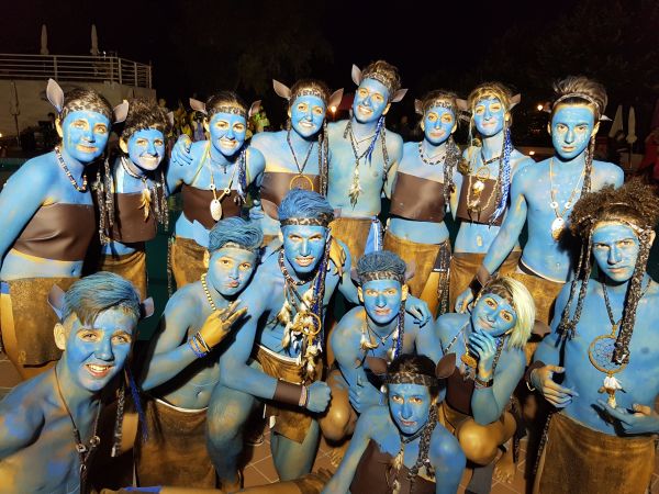 Persone truccate di blu in gruppo sorridono.