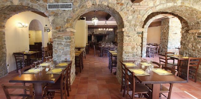 Ristorante con archi in pietra e tavoli apparecchiati.