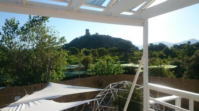 Vista di una collina con torre da una terrazza.