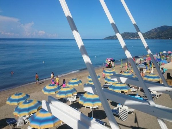 Spiaggia con ombrelloni e mare calmo.