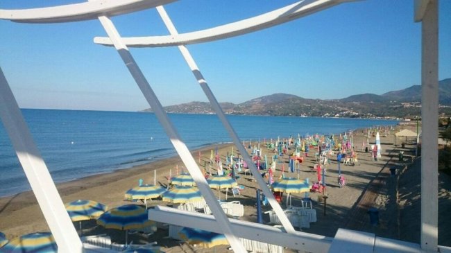 Vista sulla spiaggia con ombrelloni colorati e mare.