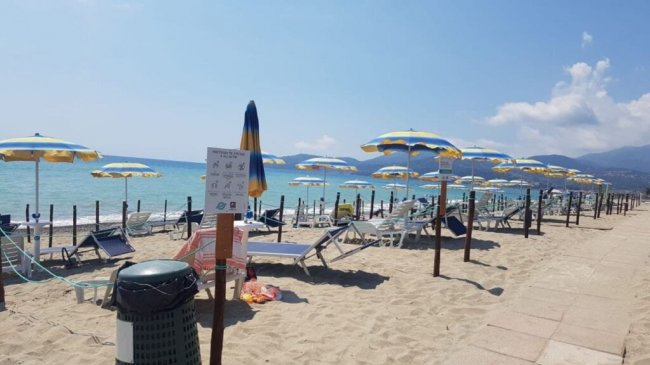 Spiaggia con ombrelloni gialli e blu.
