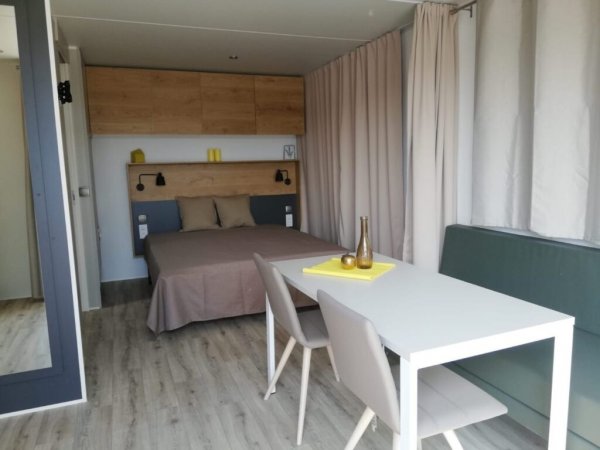 Interno moderno con letto, tavolo e sedie.