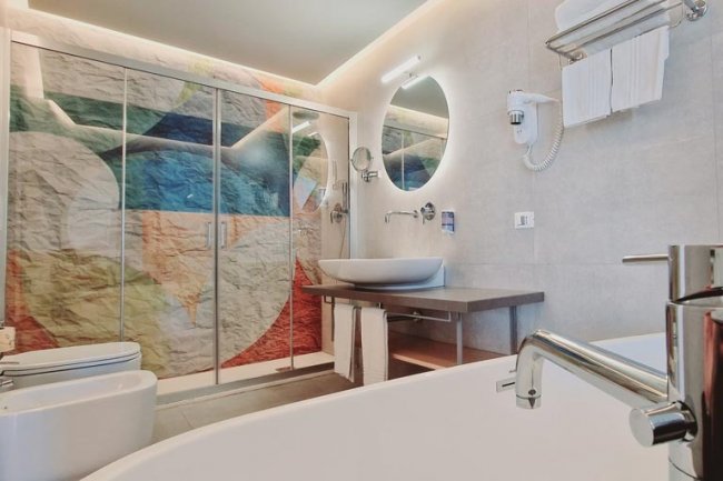 Bagno elegante con parete colorata e lavabo ovale.