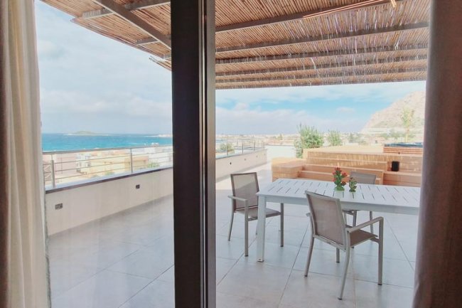 Tavolo e sedie su terrazza con tettoia.