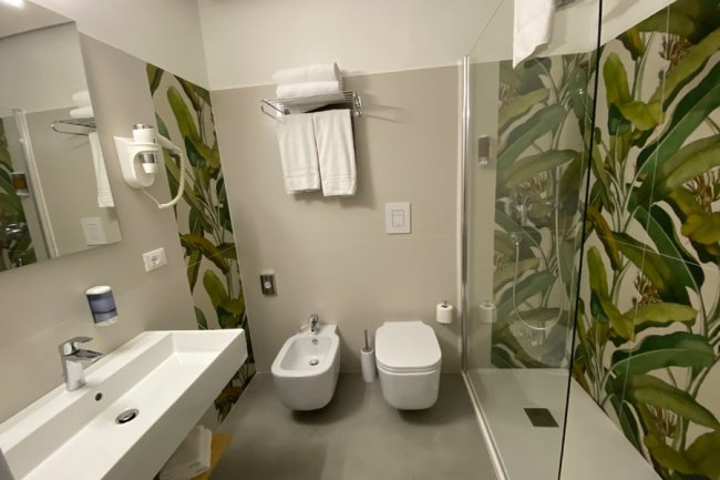 Bagno moderno con doccia, lavabo e bidet.