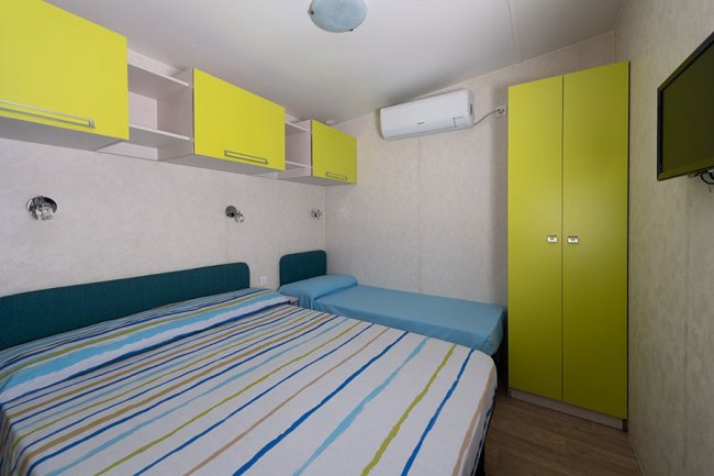 Camera con due letti e armadio giallo.