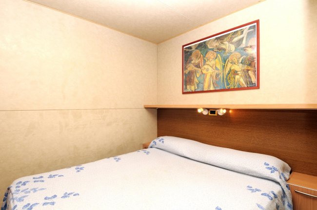 Camera matrimoniale con quadro sopra il letto.